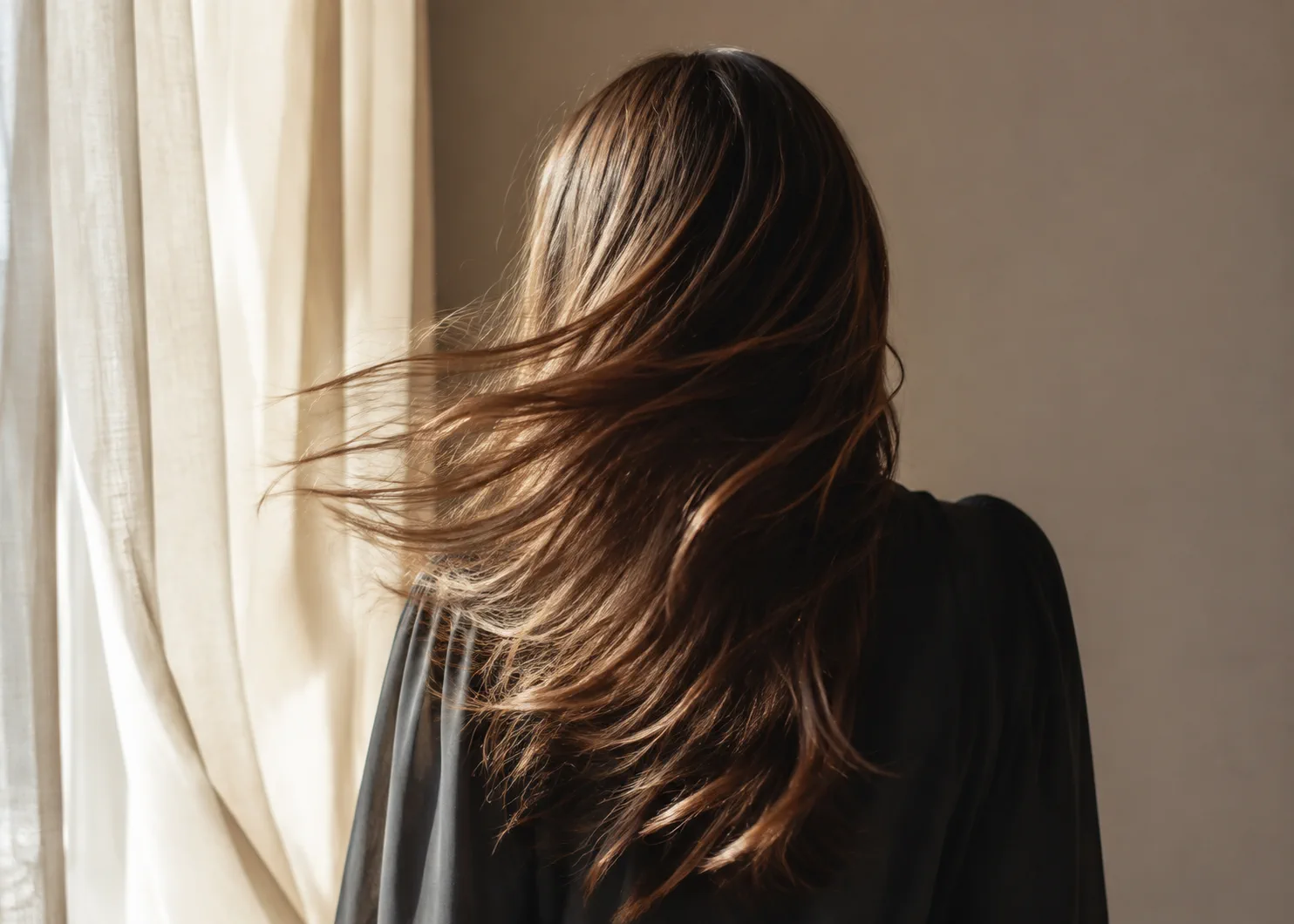Capelli mossi che si muovono nella luce naturale di una finestra